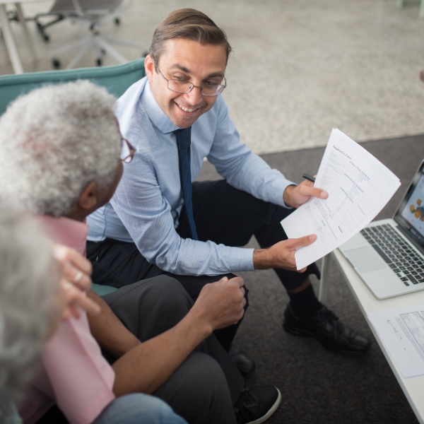 A financial adviser meeting with a couple in a bright, contemporary office